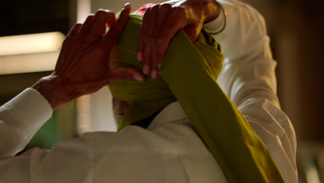 Close-Up-Studio-Shot-Of-Senior-Sikh-Man-With-Beard-Tying-Fabric-For-Turban-Viewed-From-Behind-Shot-In-Real-Time-1